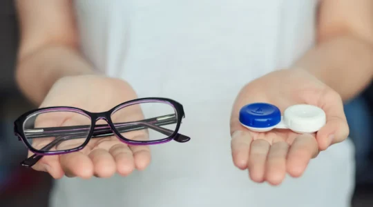 Un opticien pose une lentille de contact sur l'œil d'une cliente dans son cabinet.