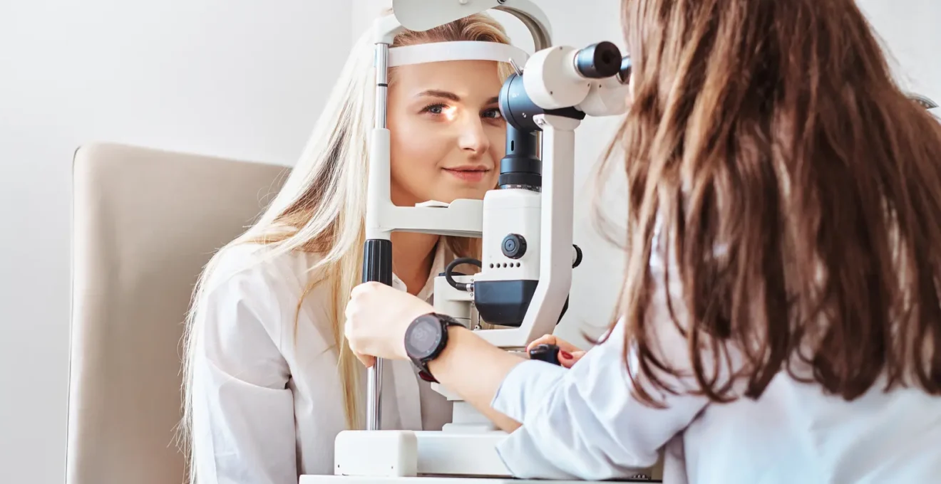 Un opticien examine une cliente à la lampe fente pendant un essai de lentilles.